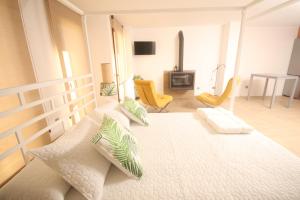 锡德自由镇APARTAMENTOS GORI SUITES HIDROMASAJE accesibles minusválidos的卧室配有一张白色大床和黄色椅子