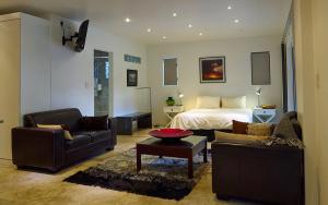 约翰内斯堡Ten Stirling Bed & Breakfast的客厅配有1张床和2张沙发