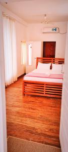 ShertallaiMarari Sailor Homes的一间卧室设有一张大床,铺有木地板