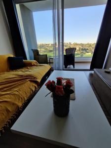 马尔萨什洛克Luxurious 2 bedroom apartment with country view的客厅,桌子上放着玫瑰花瓶