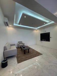 艾卜哈قمم بارك 3 Qimam Park Hotel的客厅配有沙发和墙上的电视