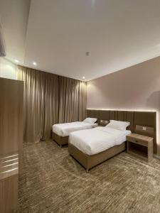 艾卜哈قمم بارك 3 Qimam Park Hotel的一间酒店客房,房间内设有两张床