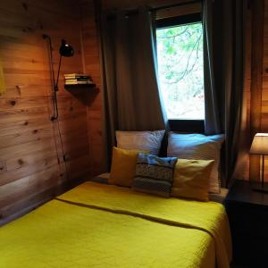 FumayCHALET Meleze Etapeboisee的一间卧室设有一张黄色的床和窗户