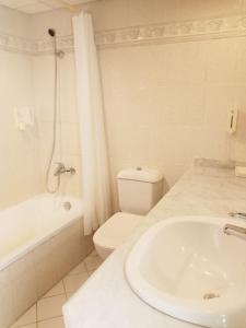 塔巴Tobya Village Hotel的白色的浴室设有水槽和卫生间。