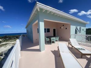 Gregory TownSephora House home的海滩上带桌椅的阳台