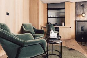 索尔登斯科恩奥西赫特酒店的客厅配有两把椅子和壁炉