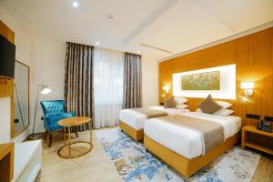 BirmandreisRoyal Sahel的酒店客房设有两张床和一张桌子。