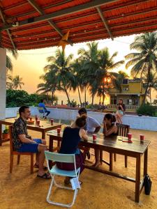 安君纳Hostel Mandala的一群坐在海滩桌子上的人