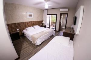 布鲁马迪纽贝洛地平线农家乐的一间带一张白色大床的卧室和一个阳台