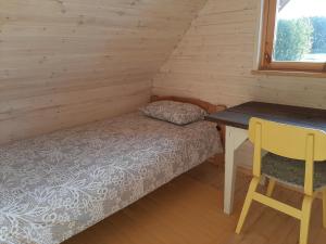 Suurepera puhkekeskuse saunamaja的一间小卧室,配有一张床和一张书桌