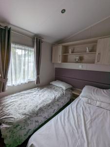 韦茅斯BEAUTIFUL LUXURY Caravan HAVEN LITTLESEA STUNNING VIEWS Sleeps 6的小型客房 - 带2张床和窗户