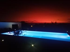 图利亚拉Villa Claire的夜晚的游泳池里点亮,有红天