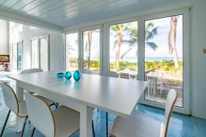 总督港Mon Soleil home的白色的用餐室配有桌椅