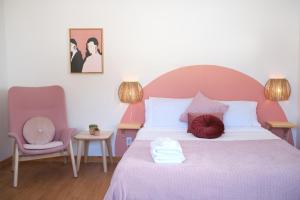 Riviere EterniteAUBERGE DU DIMANCHE - Riviere-Eternite, Pres du Fjord-du-Saguenay et de l'Anse-Saint-Jean的一间卧室配有一张带粉红色床头板的大床