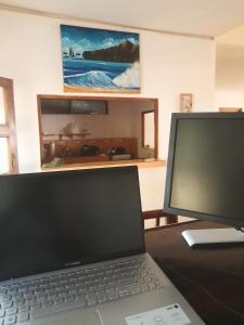 波波约Popoyo Surfcamp的电脑坐在桌子上,带有显示器