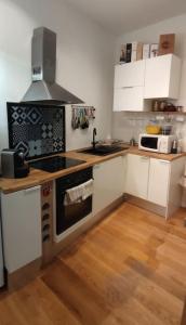 南特CŒUR MENOU, Radis'son & PARKING的厨房配有白色橱柜和炉灶烤箱。