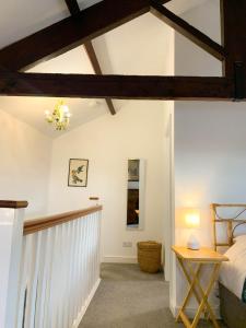 Llancarvan2 Stable Cottage, Llanbethery的卧室拥有白色的墙壁,配有一张床和一张桌子