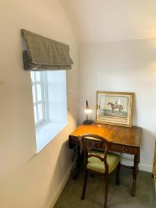 Llancarvan2 Stable Cottage, Llanbethery的一张木桌,靠窗边摆放着椅子