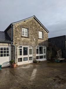 Llancarvan2 Stable Cottage, Llanbethery的砖屋,有白色门和车道