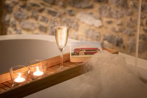 西内La petite Reuleau - Gites champêtre le "FENIL" et la "FERMETTE et son sauna privatif"的一张桌子,上面放着一杯香槟和蜡烛
