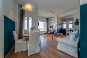 Ágios NikólaosKnots apartments的客厅配有桌子和白色椅子