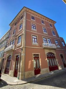 莱萨·达·帕尔梅拉Porto.Leça - Studios and Apts (Apt H)的街道上一座带红门的大型砖砌建筑