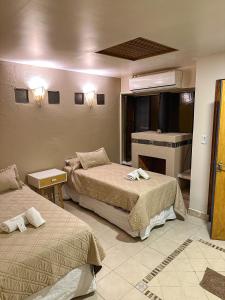 圣萨尔瓦多德朱Hotel ICONICO JUJUY Centro的酒店客房设有两张床和壁炉
