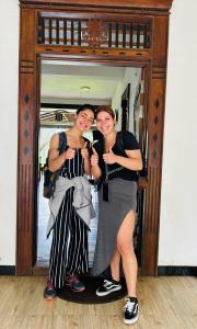 波隆纳鲁沃Heritage villa polonnaruwa的两个女人正站在镜子前