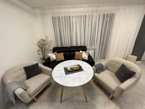 布尔加斯Hilton Burgas Holiday Home的客厅配有桌子和两把椅子