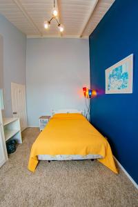 乔治敦JR Apartments的一间卧室配有一张黄色的床和蓝色的墙壁