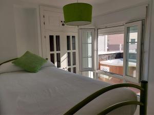 加的斯ÁTICO VICTORIA BEACH的一间卧室设有一张床和一个大窗户
