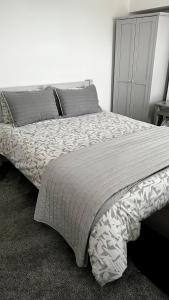 雷纳姆Modern 2 Bed House in Rainham, Kent - Central Location的一间卧室配有一张大床和灰色床头板