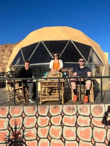 瓦迪拉姆Revan Rum Luxury Camp的三人坐在帐篷前
