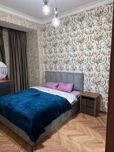 第比利斯KING SUITE APARTMENT lN TBILISI的一间卧室配有一张带蓝色毯子的床