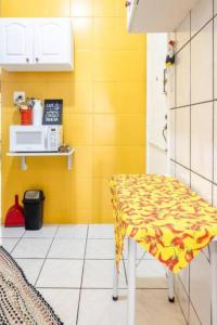 里约热内卢Hotel Mama! Copacabana (Posto1 -Leme)的厨房配有桌子和黄色的墙壁
