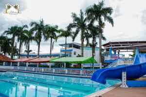 圣何塞德尔瓜维亚雷Centro Vacacional Las Palmas的一个带蓝色水滑梯的大型游泳池