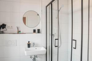 盖尔森基兴Buer Appartment的带淋浴、盥洗盆和镜子的浴室
