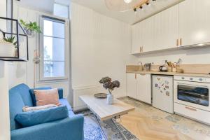 万塞讷Joli appartement bois de Vincennes, metro 1, rer A的客厅配有蓝色的沙发和桌子