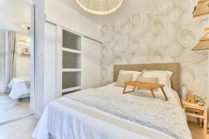 万塞讷Joli appartement bois de Vincennes, metro 1, rer A的一间卧室配有一张木桌和一张床铺。