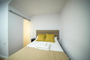 维拉·雷阿尔Apartamentos do Corgo的一间卧室配有一张带两个黄色枕头的床