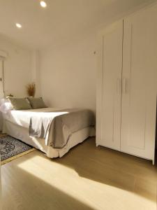 马拉加Casa La Victoria的一间卧室配有床和白色橱柜