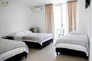 圣何塞德尔瓜维亚雷Centro Vacacional Las Palmas的一间卧室设有两张床和大窗户