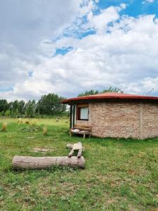 图努扬Buda de Uco Lodge的一块地里的砖头建筑,有木头