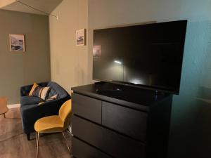 巴勒鲁普Jonstrupvejens Apartments Lejl C的客厅配有黑色梳妆台和平面电视