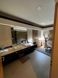科隆Los Juanitos的一间带两个盥洗盆和大镜子的浴室