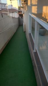 库亚巴Hotel Amadeu´s的大楼内的阳台铺有绿色地板