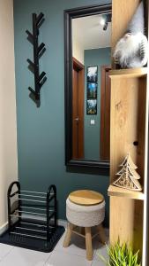 波罗维茨The Green apartment的浴室设有镜子、长凳和凳子