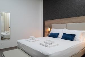 庞贝MyHouse Pompei的卧室配有带蓝色枕头的大型白色床