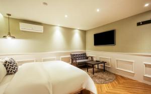 釜山Hotel the Sweet的卧室配有床、椅子和平板电视。