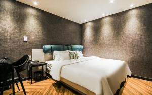 釜山Hotel the Sweet的卧室配有白色的床、书桌和椅子